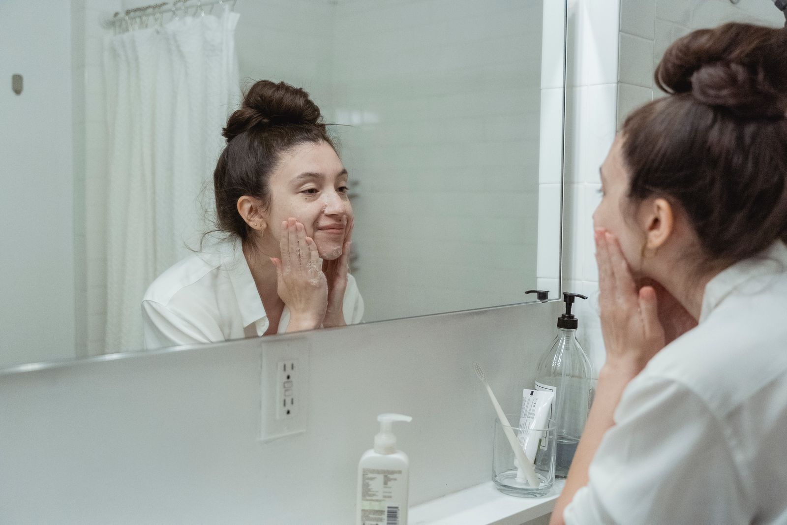 A woman in a softly lit skincare ritual with her face visible