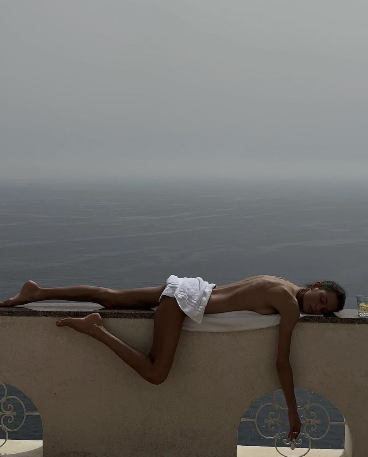 Woman resting on a Mediterranean terrace above the sea