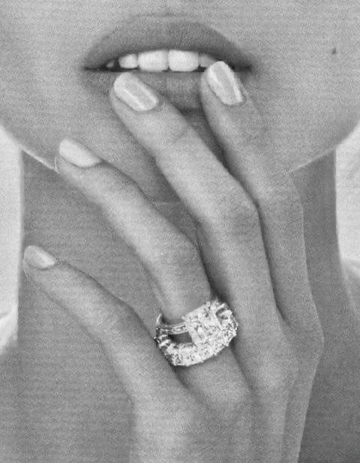 Black-and-white close portrait of a hand wearing a statement diamond ring