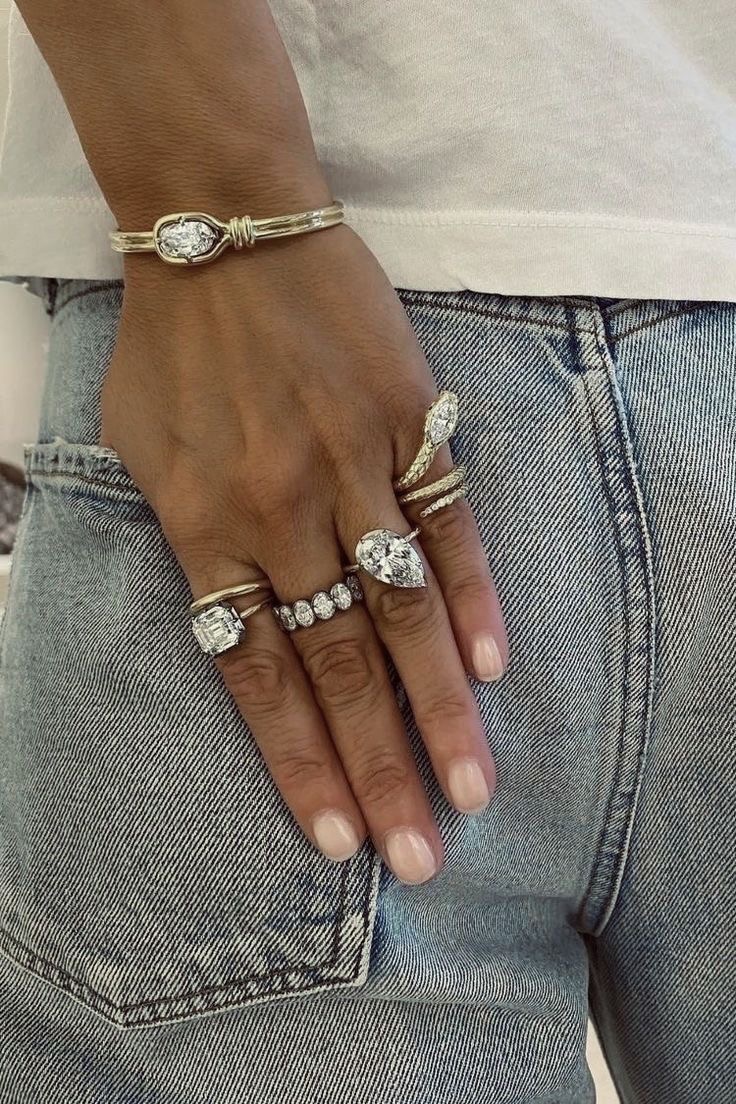 Hand wearing an assortment of sculptural diamond rings