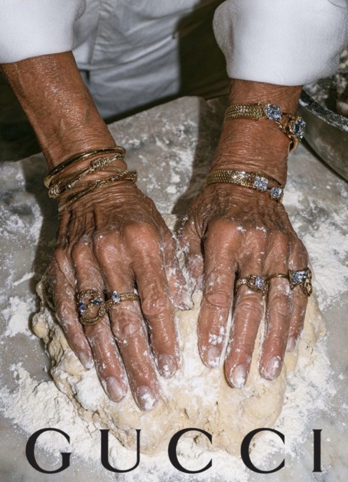 Hands wearing rings and bracelets while making bread