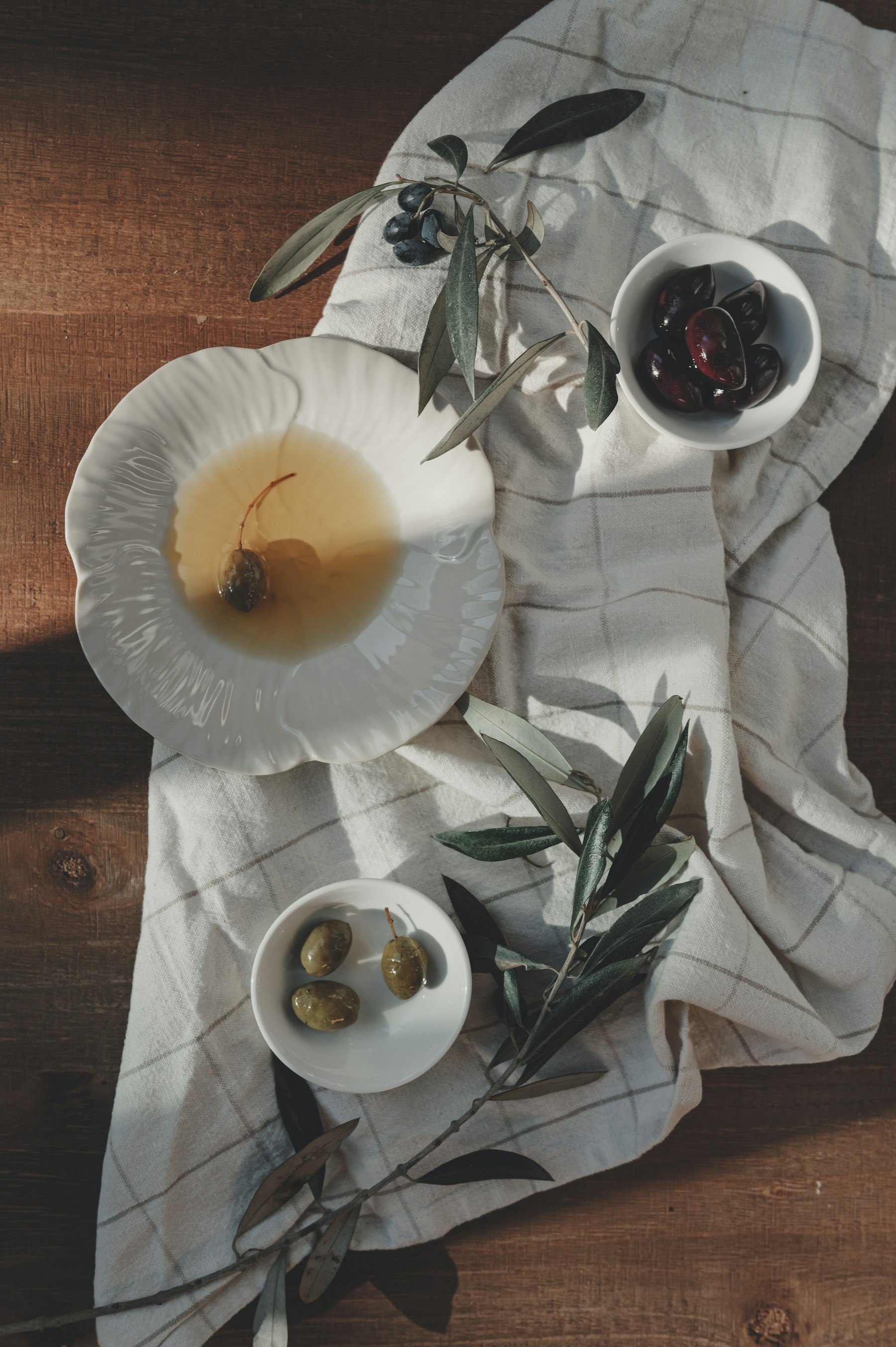 Olive oil, olives and branches arranged as a Mediterranean still life