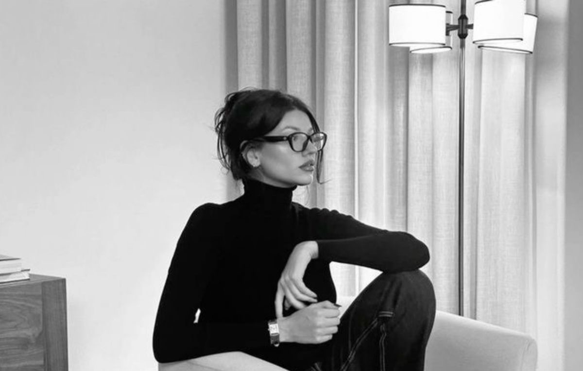 Woman in glasses sitting quietly in an interior